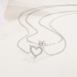 Double-layered necklace with sparkling paved heart pendant and a single round-cut cubic zirconia