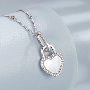 Close-up of S925 silver heart lock pendant with white shell inlay on a fine link chain