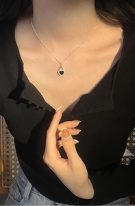 Detail of s925 silver heart necklace with black onyx pendant worn on collarbone