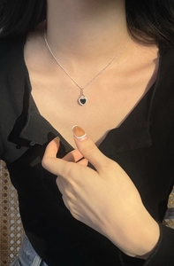 Close-up of S925 silver heart necklace with black onyx inlay on a model's neck