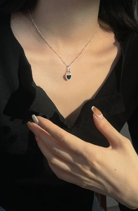 Close-up of S925 silver necklace featuring a black onyx heart pendant with lace edges