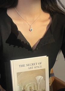Close-up of S925 sterling silver heart necklace with black onyx worn by model