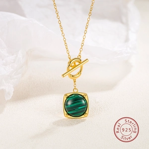 Macro detail of S925 silver gold necklace with malachite pendant and toggle clasp