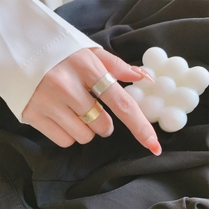 Dettaglio macro di ampi anelli in argento sterling S925 martellato in oro e argento