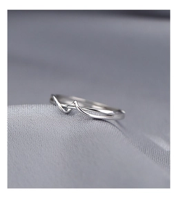 Dettaglio macro di un anello minimalista in argento S925 a linee ondulate su raso grigio