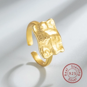 Macro detail of 925 sterling silver hammered gold ring with irregular foil texture
