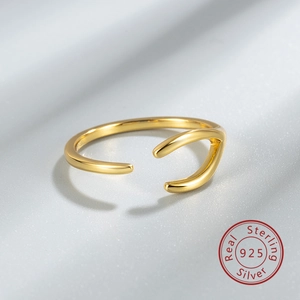 Detailed view of wave-shaped S925 sterling silver gold-plated ring on silk texture