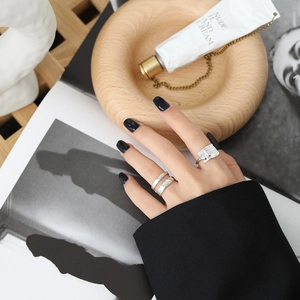 Detail shot of irregular textured silver rings and double-layer band on a model hand