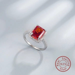 Macro detail of S925 sterling silver ring featuring a halo-set rectangular red gemstone