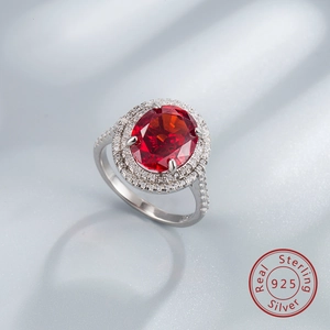 Détail macro d'une bague en argent S925 avec gemme rouge ovale et halo de zircons