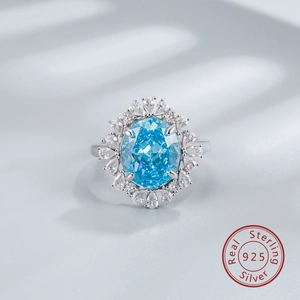 Macro shot of 925 silver ring with oval blue sapphire and pear-cut zircon halo stones