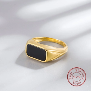 Macro shot of 925 sterling silver gold plated signet ring with black agate stone inlay