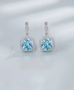 Détail de boucles d'oreilles halo en argent 925 avec zircon bleu et poinçon de métal
