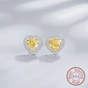 Macro shot of 925 silver heart stud earrings featuring yellow gems and halo diamonds