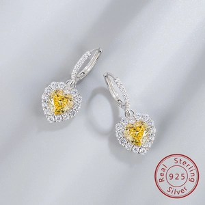 Macro shot of 925 sterling silver earrings with yellow heart-cut gemstone and pavé diamonds