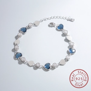 Détail macro du bracelet en argent S925 avec cristaux de cœur bleus et fermoir mousqueton