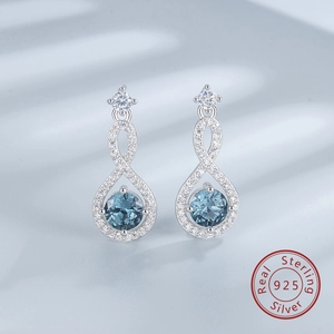 Detailed macro view of S925 sterling silver infinity earrings with blue sapphire gemstones