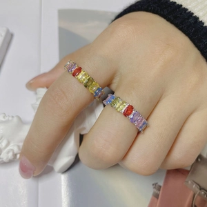 Gros plan sur des bagues S925 or et argent avec des zircons arc-en-ciel rectangulaires