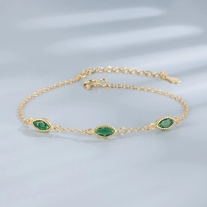 Detail of 18K gold plated bracelet featuring three marquise-cut green emerald zircons