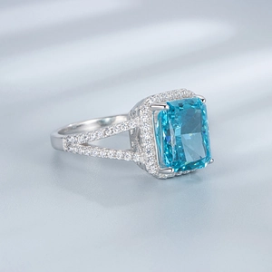 Detailed macro view of an emerald cut blue gemstone ring with a split shank silver band