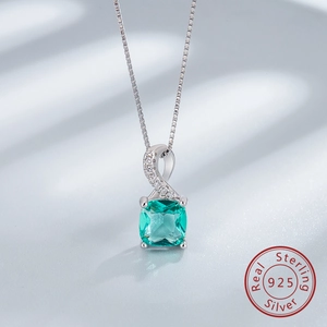 Gros plan d'un pendentif émeraude carrée sur une chaîne en argent sterling 925 massif