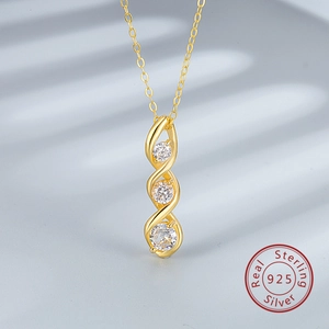 Détail du collier en argent 925 doré orné de trois pierres blanches rondes polies