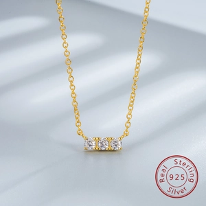 Detail of three sparkling cubic zirconia stones on a gold-plated 925 silver chain