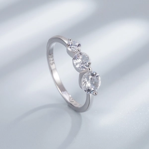 Detailed side view of 925 sterling silver three-stone ring with round zircon inlay