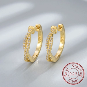 Gros plan de boucles d'oreilles torsadées en argent S925 doré avec zircons brillants