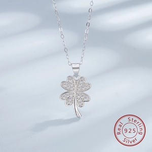 Macro shot of 925 sterling silver four-leaf clover pendant with pavé set zircon stones