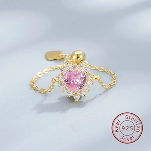 Detailed macro view of 925 sterling silver heart ring with pink zircon and sliding chain