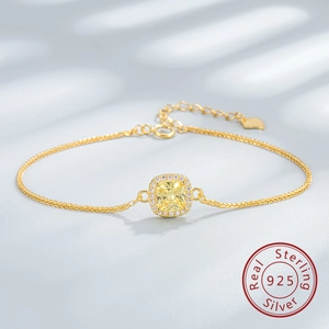 Macro shot of 925 silver gold bracelet with a square yellow zircon and halo setting