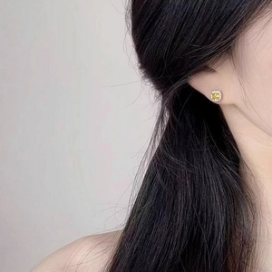 Detail of S925 silver stud earring featuring square yellow stone and halo setting