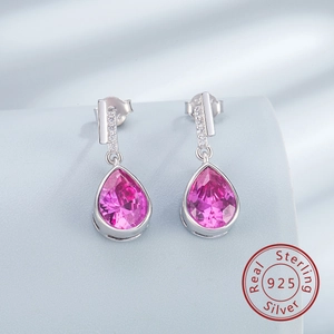 Vue macro des boucles d'oreilles goutte en argent 925 avec pierre rose et détails en zircon