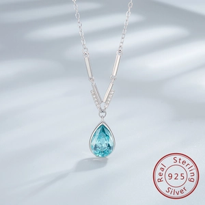 Detailed macro view of pear-cut light blue gemstone and 925 sterling silver V-shape bale
