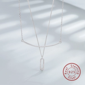 Detail of 925 sterling silver safety pin necklace with pavé zircon and curved bar pendant