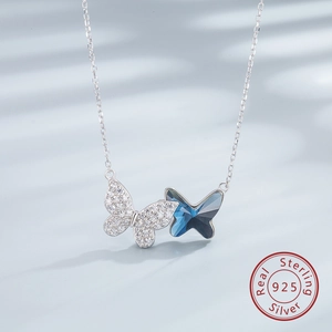 Macro detail of S925 sterling silver butterfly pendant with blue crystal and pavé zircon