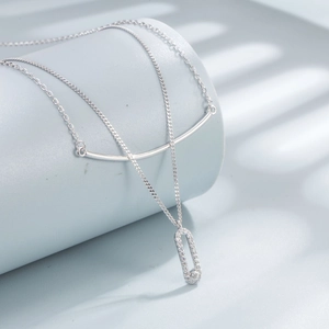Macro detail of double-layer S925 silver necklace with sparkling zircon geometric pendant