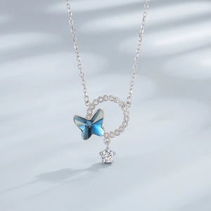Close-up of S925 silver necklace with crystal butterfly and star pendant on silk