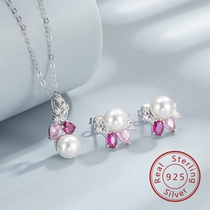 Close-up of pearl jewelry set with pink stones and 925 silver on blue silk fabric