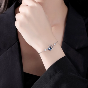 Detailed shot of a silver butterfly bracelet with blue crystals on a female wrist