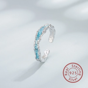 Vista macro de anillo de plata S925 con textura irregular e incrustación de esmalte azul