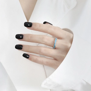 Primer plano de anillo de plata S925 con textura azul en modelo con camisa blanca