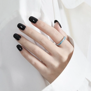 Anillo abierto de plata S925 con textura azul lucido en dedo con manicura negra elegante