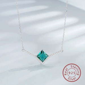 Close-up of S925 sterling silver V-shape pendant with princess cut emerald green stone