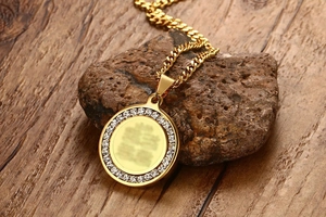 Macro shot of gold-plated circular zircon pendant resting on a natural stone surface