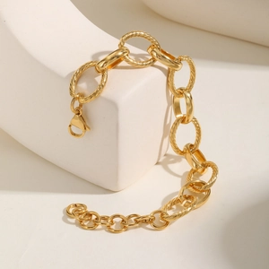 Detail of 18K gold plated interlocking link bracelet with textured oval rings and lobster clasp