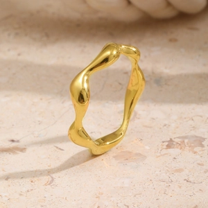 Macro view of gold irregular wavy ring featuring polished stainless steel finish