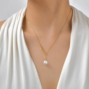 Collier en Y plaqué or 18 carats avec anneau ovale et perle d'imitation porté sur modèle