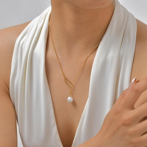 Détail du collier chaîne serpent en or 18K avec pendentif perle sur un modèle